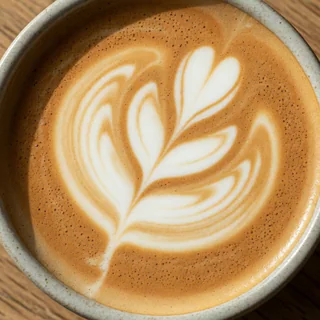 Flat white with rosetta latte art in a ceramic cup